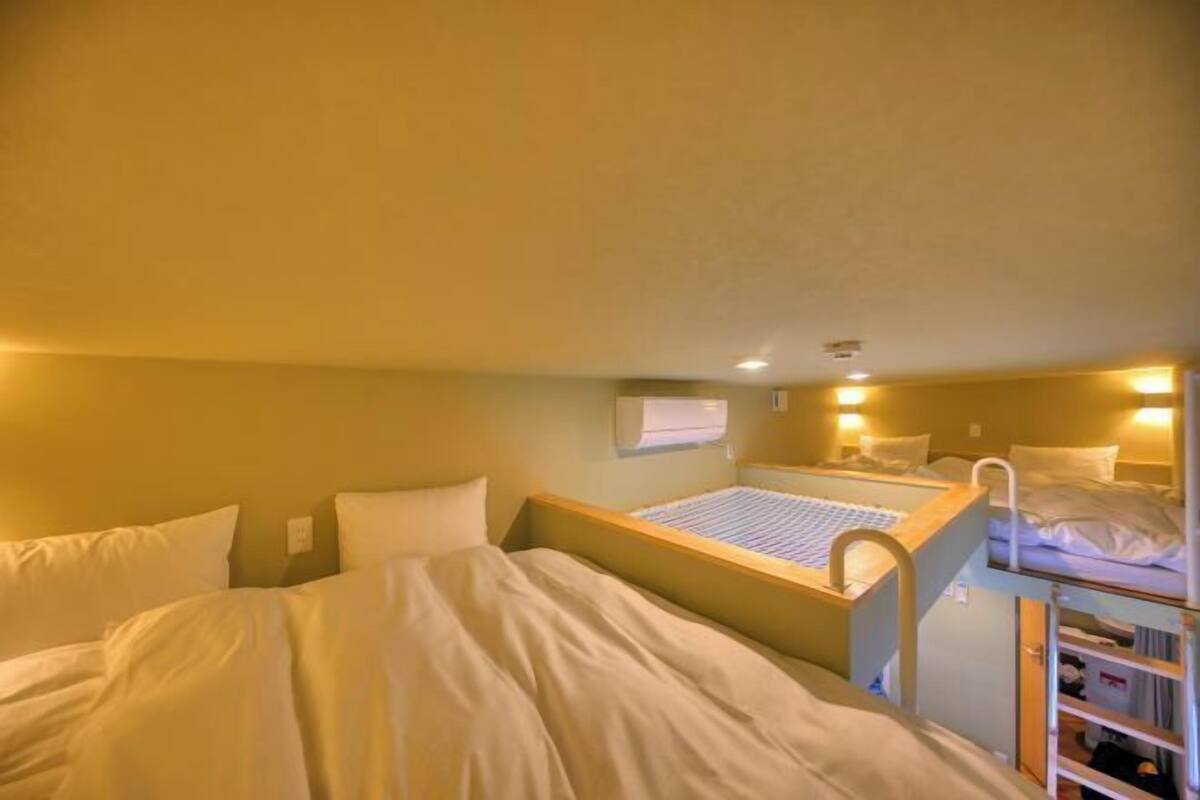A bunk bed room with a desk and a shelf.