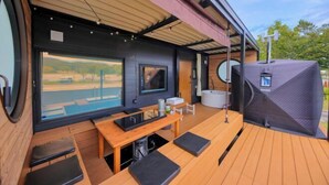 A modern outdoor seating area with a table, chairs, and a large window overlooking a landscape. - Piilo asobi＆stay (Yamanakako)