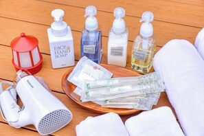 A wooden surface with various toiletries including face soap, shampoo, conditioner, and a hairdryer. - Piilo asobi＆stay (Yamanakako)