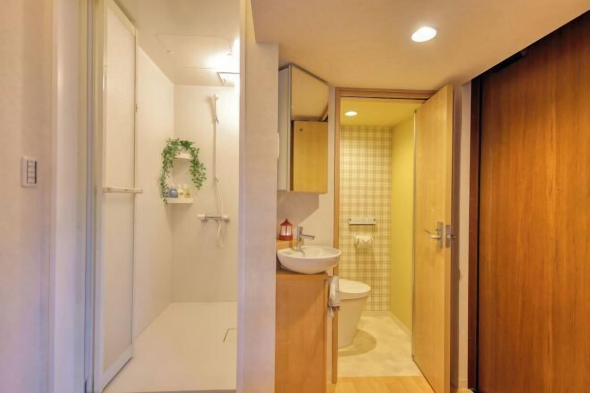 A bathroom with a shower, sink, and toilet.