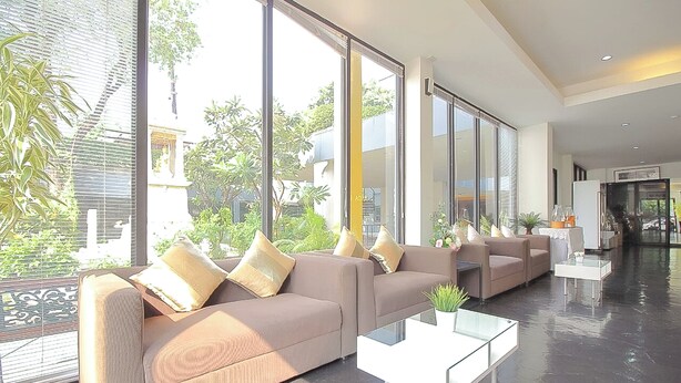 A spacious living area with large windows, a sofa set, and a coffee table.