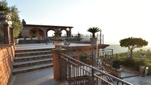 A staircase leading to a terrace with a view of the sea.