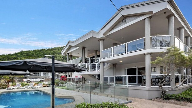Un hôtel moderne doté d’une piscine, d’un espace extérieur aménagé et d’un patio couvert.
