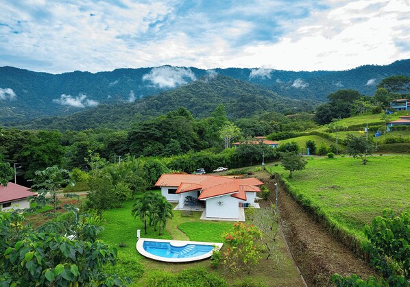 A residential area with houses, a swimming pool, and lush greenery.