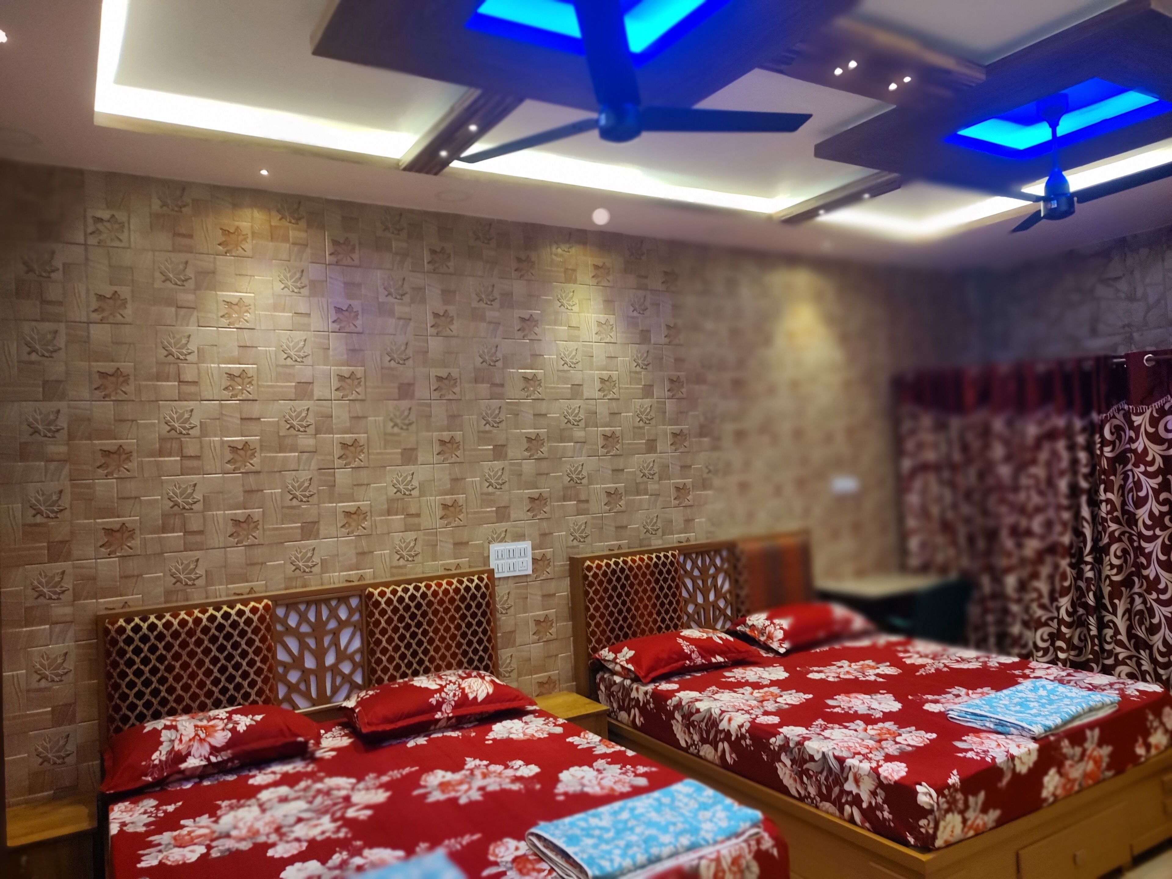 Een hotelkamer met twee bedden, houten hoofdborden en een kamer met een patroon op de muur.
