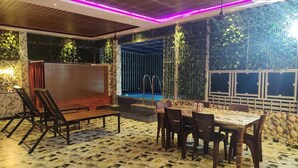 An outdoor patio with a pool, seating area, and decorative plants. - Mary Land  Homestay - A  "Private Pool Villa" Near Trivandrum Airport and Beach. (Thiruvananthapuram)