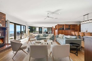 Un salon moderne doté d’une cheminée, d’un espace salon et offrant une vue sur l’extérieur.