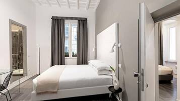 Un dormitorio moderno con una cama grande, cabina de ducha de vidrio y vistas al exterior.