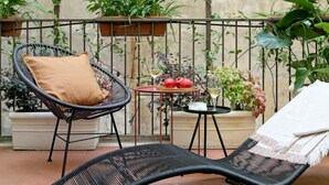 A balcony with wicker chairs, a table with a potted plant, and a potted tomato plant. - N-SPACE MODERN GUEST ROOMS (Rome)