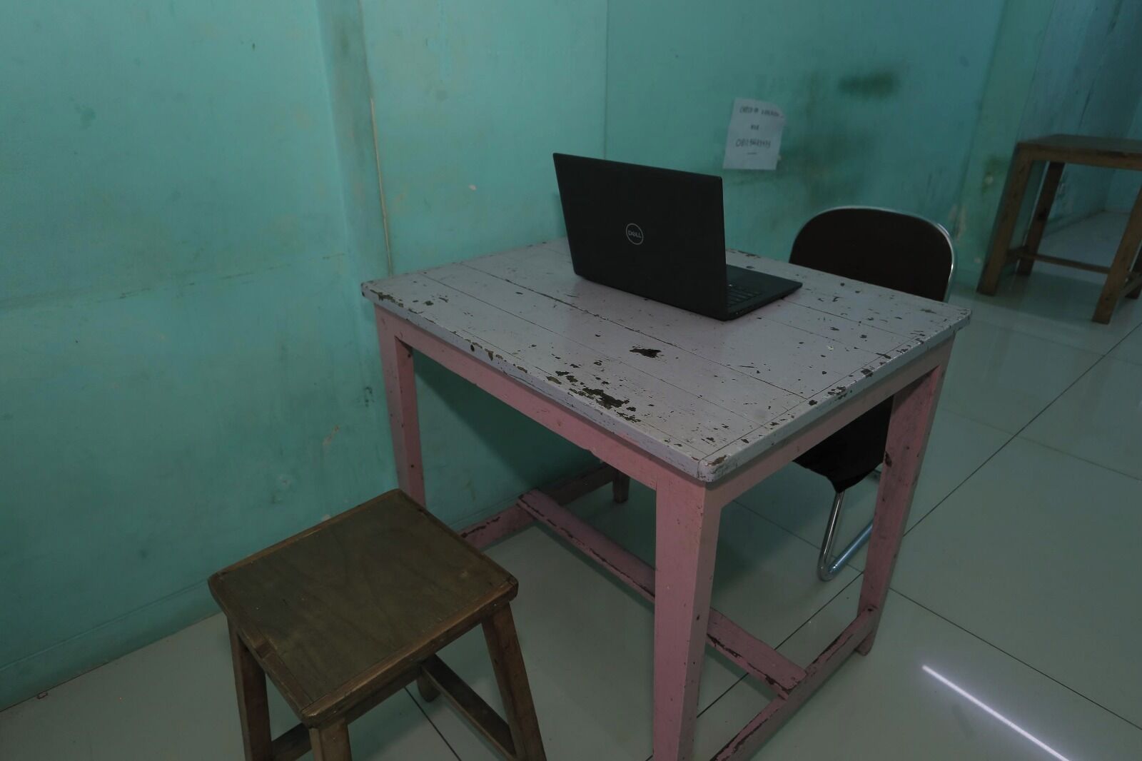 Una habitación pequeña con un escritorio, una computadora portátil y una silla.