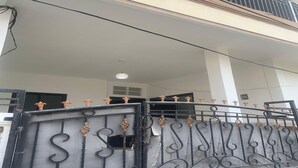 A gated entrance with decorative metalwork and a balcony above.