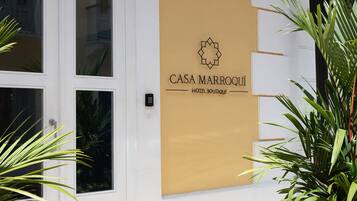 A building facade with a sign reading "CASA MARROQUI HOTEL BOUTIQUE".