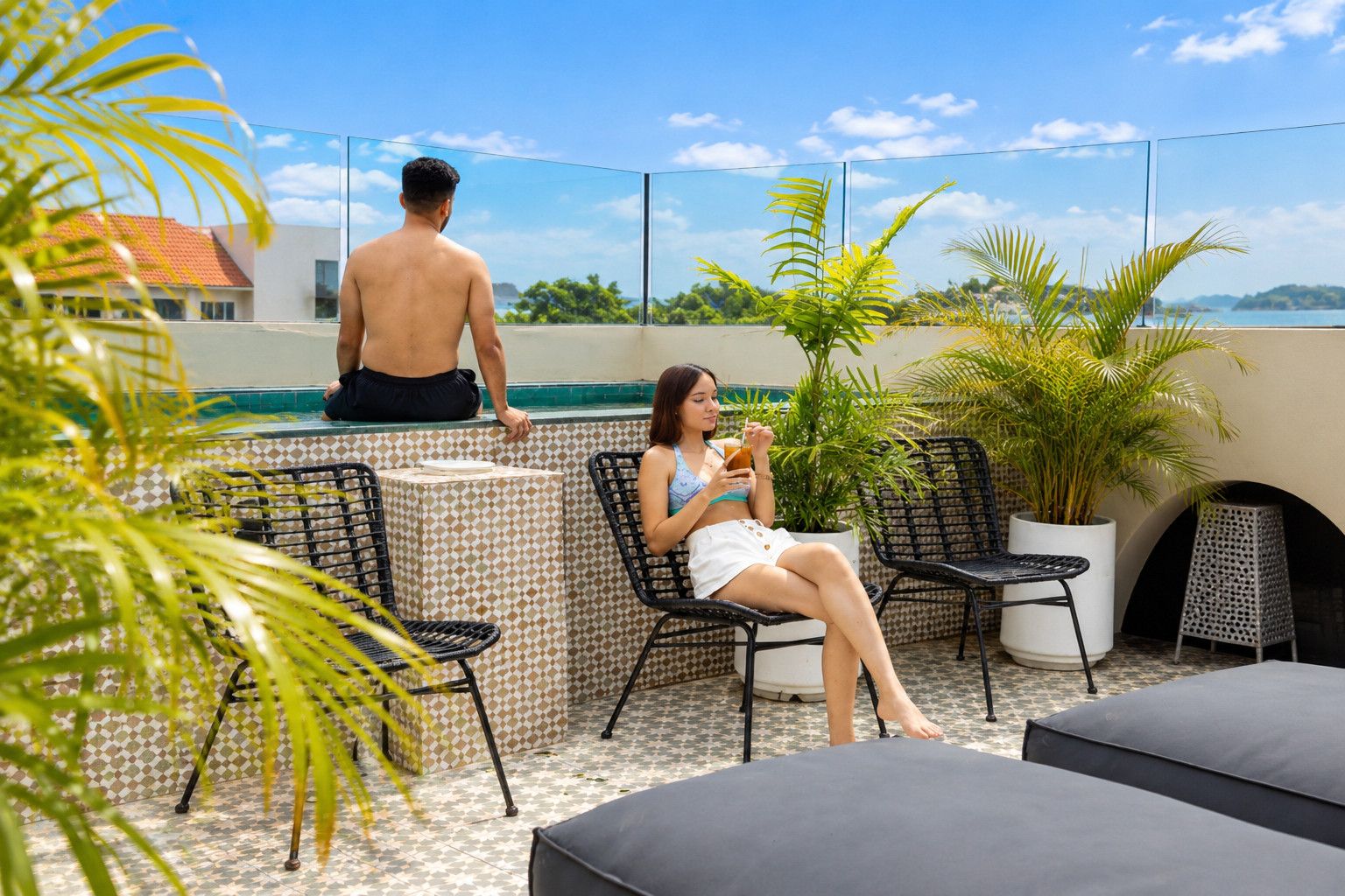 Eine Dachterrasse mit Pool, Liegestühlen und Topfpflanzen.
