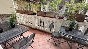 A terrace with outdoor furniture, potted plants, and a white balustrade. - In Center Lucca Lovely Home (Lucca)