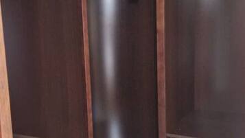 A room with a wooden door, a vertical wooden column, and a dark wooden wall.