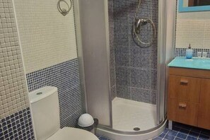 Baño con ducha, inodoro y lavamanos.
