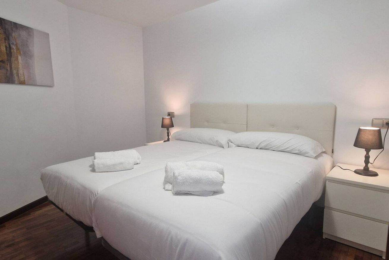 Ein Hotelzimmer mit einem großen Bett, zwei Nachttischlampen und einem Nachttisch.