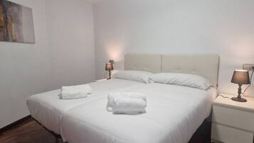 Ein Hotelzimmer mit einem großen Bett, zwei Nachttischlampen und einem Nachttisch.