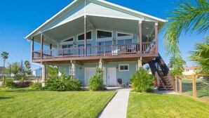 A two-story house with a covered porch, a front door, and a staircase leading to the upper level.