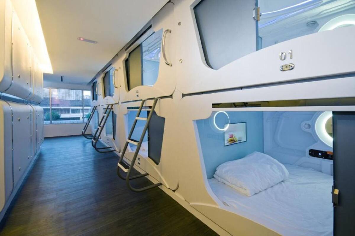 A train car with bunk beds, a ladder, and a window providing a view of the outside.