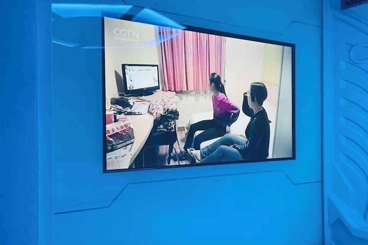 A modern room with a large wall-mounted TV displaying a scene.