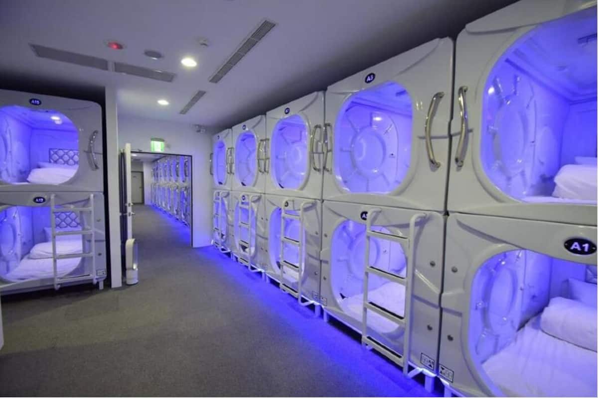 A row of individual massage pods with a blue light, each pod labeled with a letter.