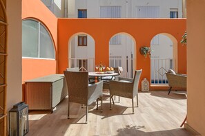 Relax in this inviting outdoor space with a dining area, wicker chairs, and a lantern.