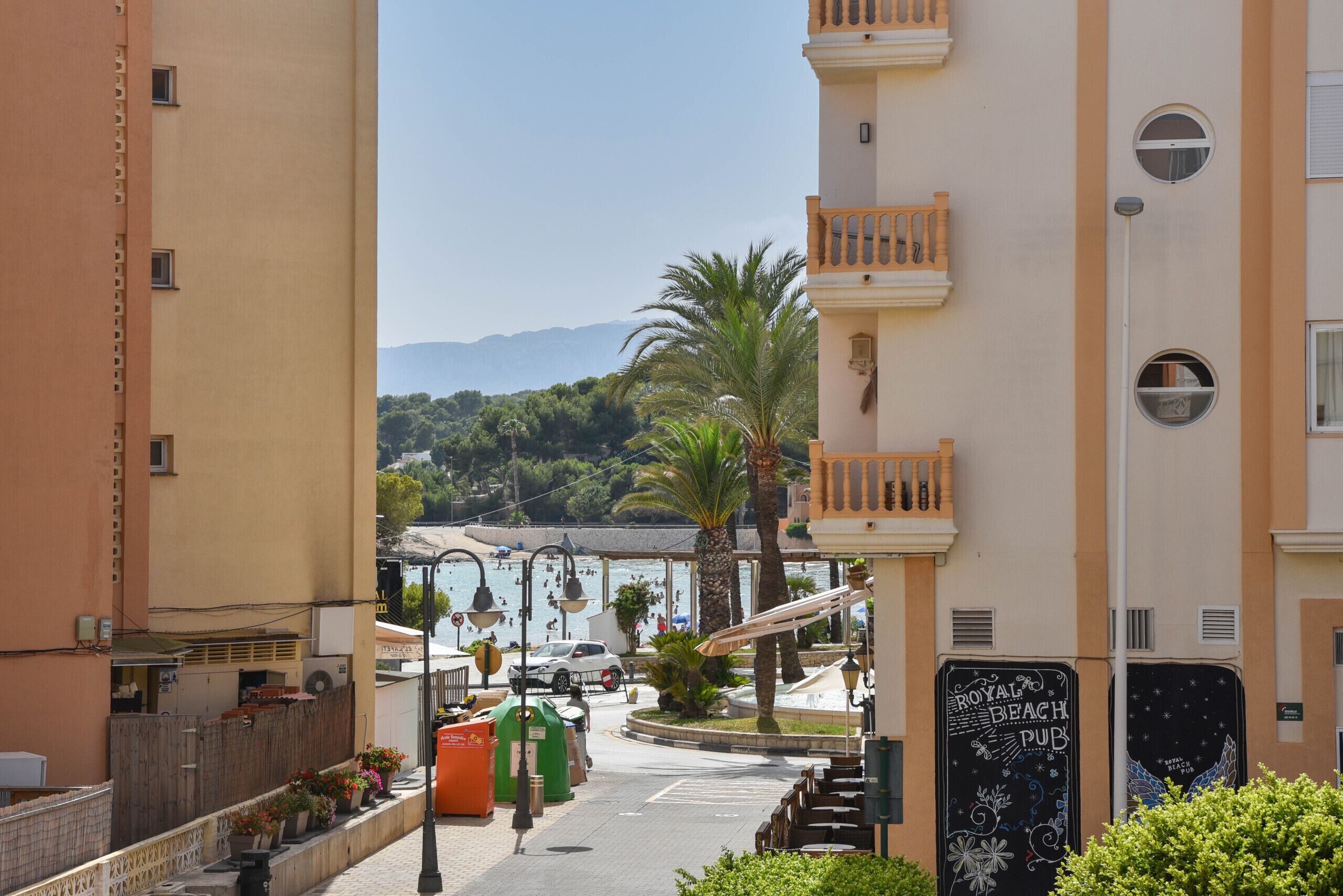 A street view with a building labeled "Royal Beach Pub" and a view of the sea in the background.