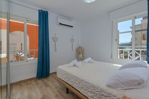 Relax in a spacious room with a large bed, balcony view, and air conditioning for a comfortable stay.