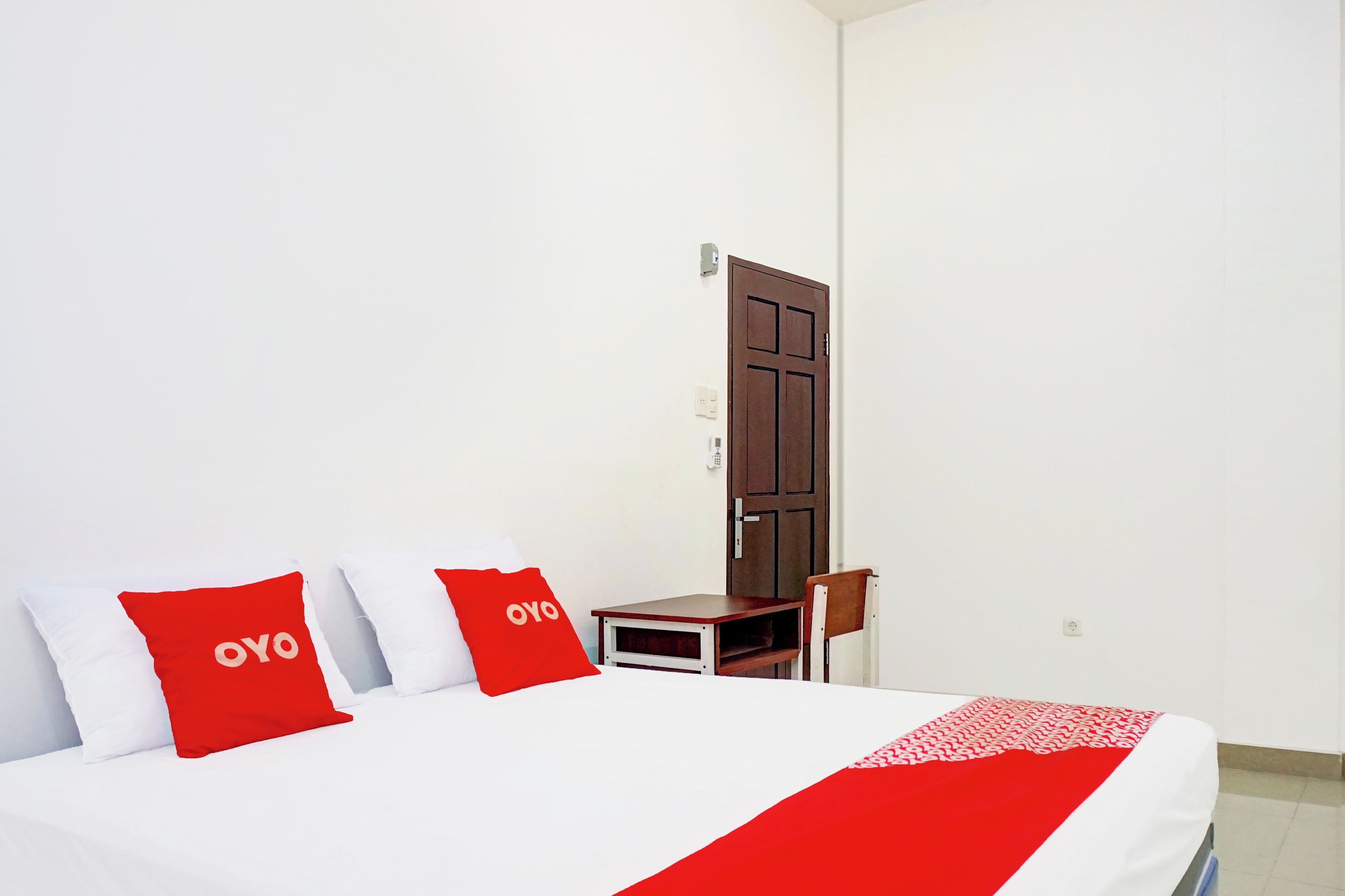 Una habitación de hotel con una cama, un escritorio y una silla.