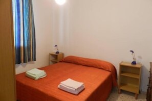 Cozy retreat with a single bed, nightstands, and a window with curtains.