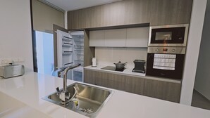 A modern kitchen with a built-in oven, a toaster, and a sink with a faucet. - STAY Diamond Apartment (Larnaca)