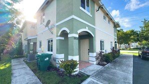 A two-story building with a green and white facade, a visible door number, and a satellite dish. - Good Vibes Sanctuary, Central Location South Miami (Cutler Bay)