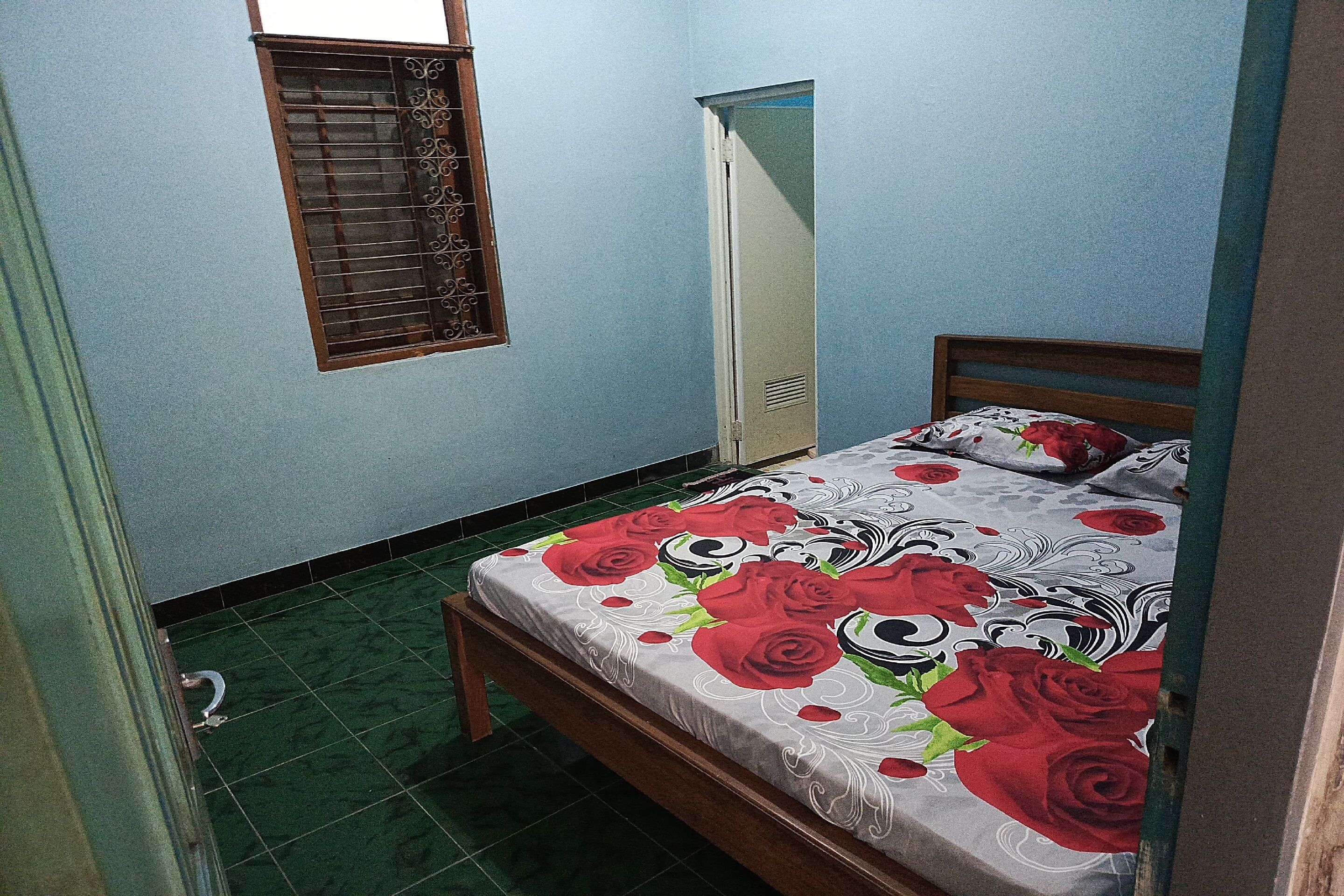 Un dormitorio pequeño y ordenado con cama, armario y ventana con barrotes.