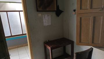 A small room with a wooden table, a chair, a wall-mounted picture, and a sign with text.