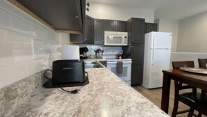 Una cocina compacta equipada con tostadora, microondas y refrigerador.