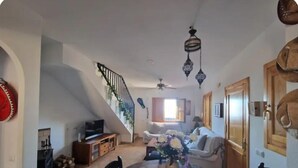 A spacious living area with a dining table, chairs, a sofa, and a staircase. - El Mirador del Berenjenal. 
¡Relajate con toda la familia!.  (Enix)