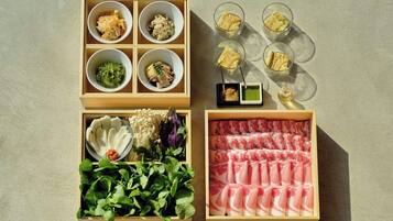 A wooden tray with various food items, including vegetables, meat, and condiments.