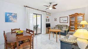 A living room with a dining table, sofa, and a cabinet. - Comeback La Casa Sin Nombre (Motril)