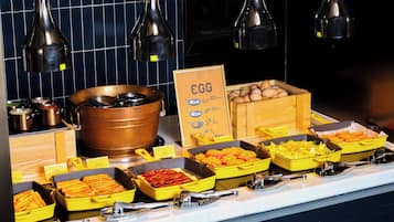 A buffet with various food items and cooking utensils.