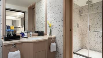 A modern bathroom with a shower, a sink, and a mirror.