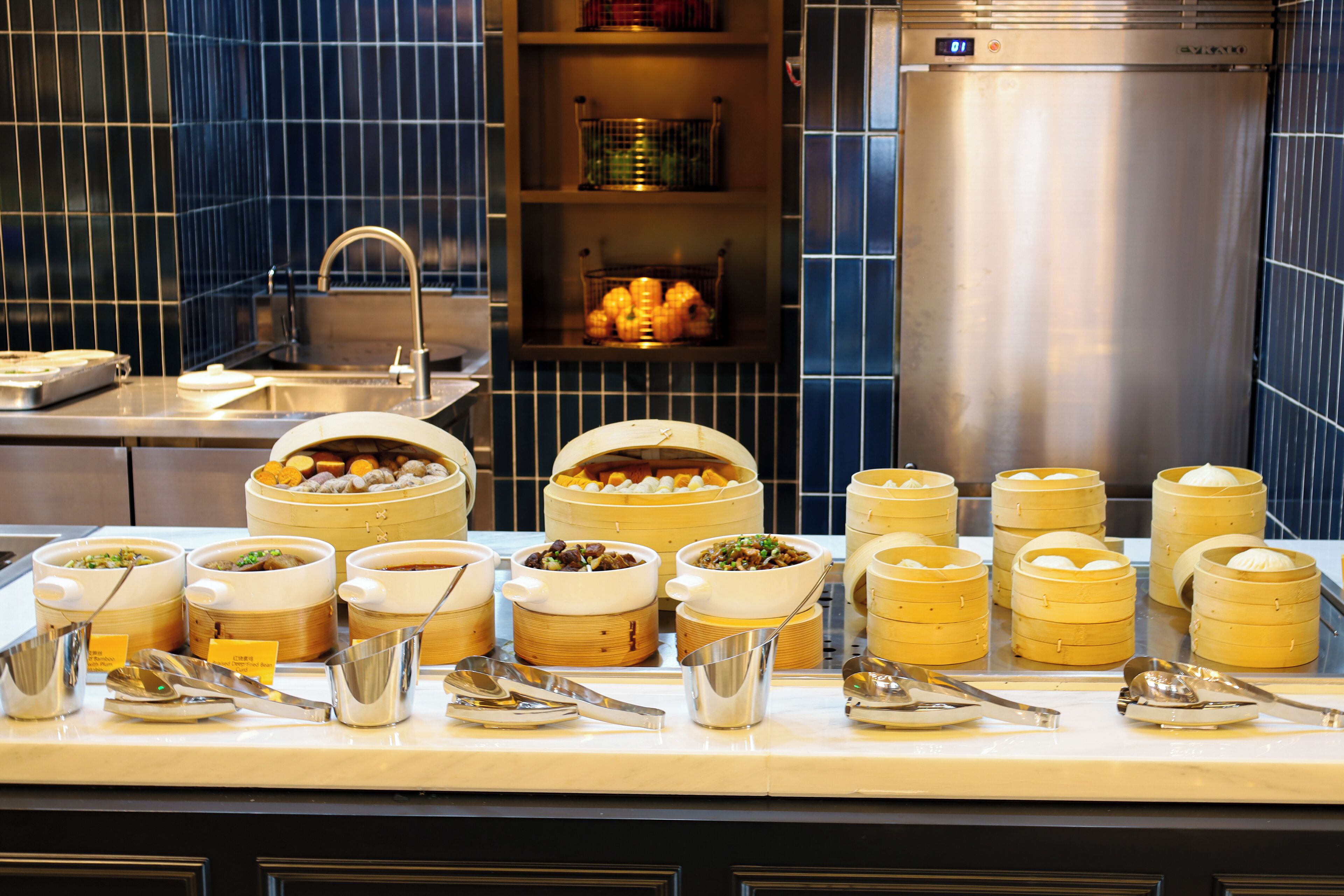 A buffet with various food items and serving utensils.