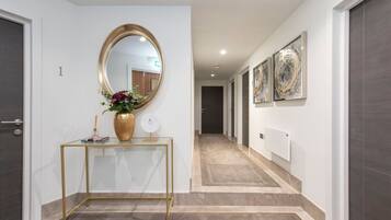 Stylish hallway with a gold-framed mirror, console table, and abstract art.