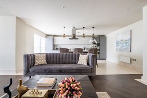 Relax in this stylish living room with a comfortable sofa, coffee table, and kitchen area.
