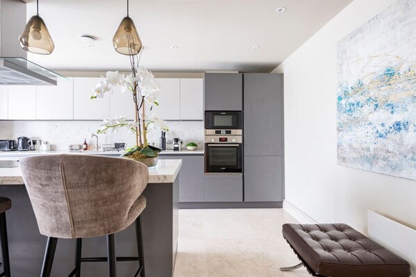 Enjoy cooking in this well-equipped kitchen with a central island, microwave, oven, and coffee machine.