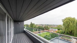 Ein Balkon mit Blick auf ein Wohngebiet, einschließlich Häuser und Bäume.