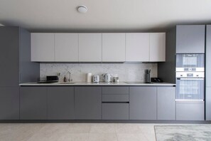 Enjoy cooking in this well-equipped kitchen with a central island, oven, and stainless steel refrigerator.