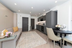 Relax in this stylish living space with a sofa, dining area, and fully equipped kitchen.