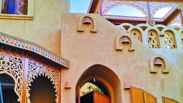 A traditional building with arched doorways and intricate wooden lattice work. - Harmony Villas Sleeps 4 With Garden (Luxor)