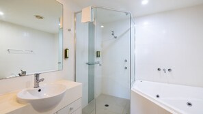 A modern bathroom with a glass-enclosed shower, a white sink, and a bathtub. - Pacific Blue 244, 255 Sandy Point Rd - pool, aircon, linen and resort features (Corlette)